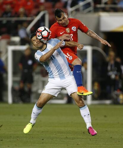 Agüero y Medel disputan el balón.