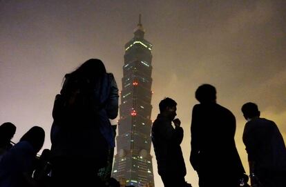 Un grupo de personas observa el rascacielos Taipei 101 de la capital de Taiwan. 