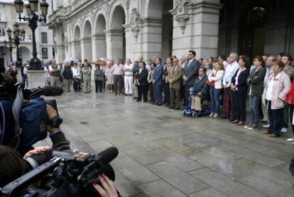 Vecinos y miembros del cabildo de A Coruña guardan un minuto de silencio frente a las puertas del Palacio de María Pita, sede del Consistorio coruñés, como muestra de condolencia por los dos menores fallecidos.