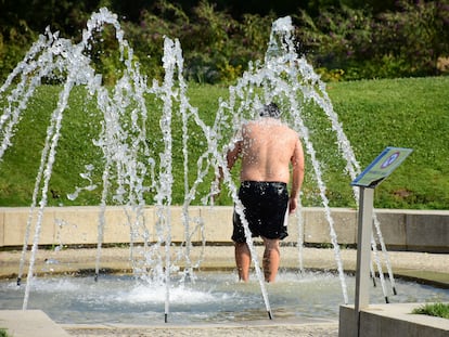 Un hombre se refresca bajo unos chorros de agua en Madrid Río a principios de julio de 2022.