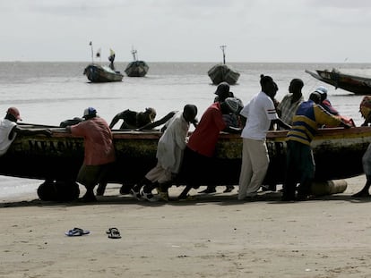 Varios senegaleses arrastran un cayuco, en una playa de Dioghe, una de las localidades de donde parten hacia Canarias. Foto de archivo.