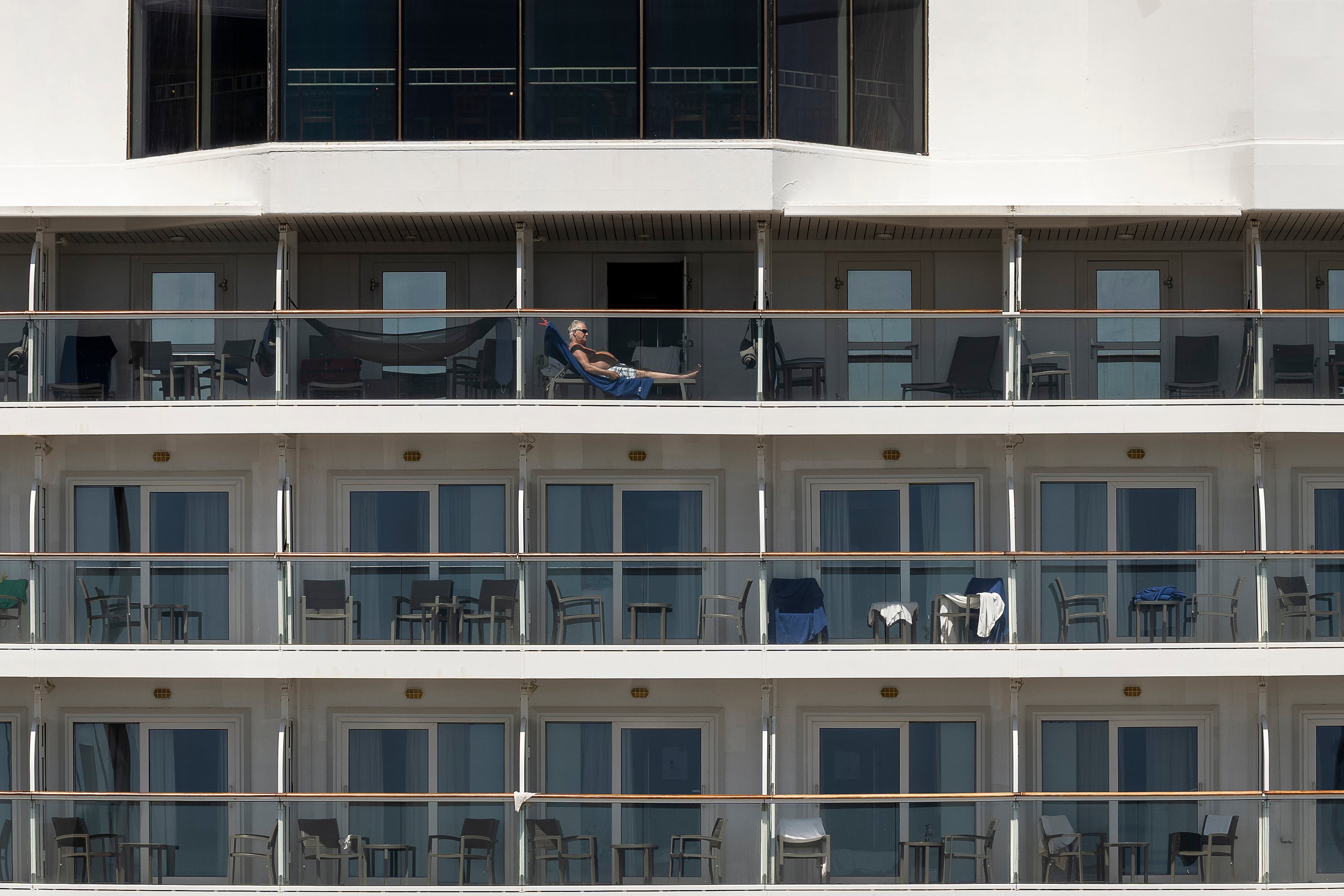 Turistas tomando el sol en un crucero amarrado en el Puerto de Barcelona.


