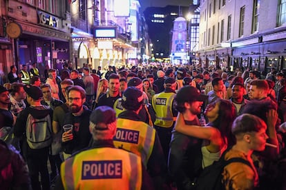 Agentes de policía caminan entre la multitud el sábado por la noche en el Soho londinense.