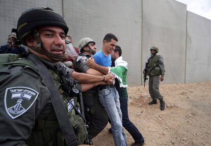 Soldados israelíes detienen a activistas extranjeros que participan en una manifestación en apoyo al pueblo palestinos, en la localidad de Walajah, cerca de la ciudad de Belén.