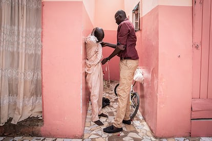 Ibrahima Seck ayuda a Abdou, quien vive en la calle en el barrio de Medina de Dakar, a vestirse tras una ducha, el 12 de julio.