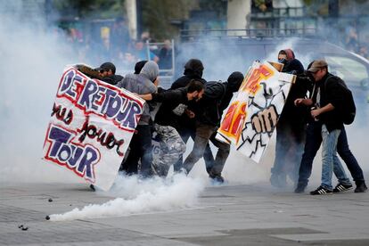 Un grupo de manifestantes se protege de un bote de gas lacrimógeno lanzado por la policía durante los enfrentamientos en Nantes.