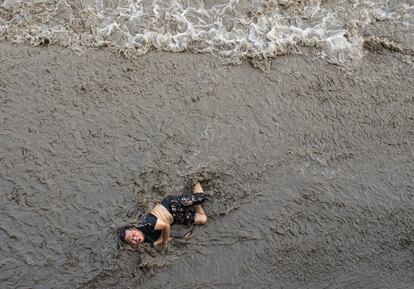 Homem que caiu de uma ponte enquanto olhava as ondas do maremoto que se aproximavam, às margens do rio Qiantang, em Hangzhou (China), em 25 de julho de 2016.