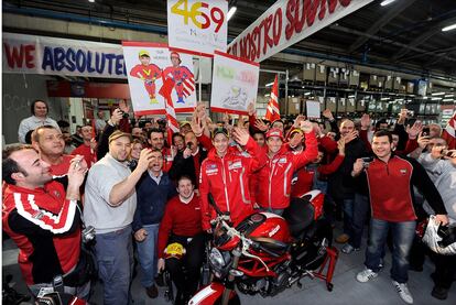 Los pilotos del equipo Ducatti de Moto GP, Valentino Rossi y Niki Hayden, posaron junto a los trabajadores de la fábrica de la marca italiana en Bolonia.