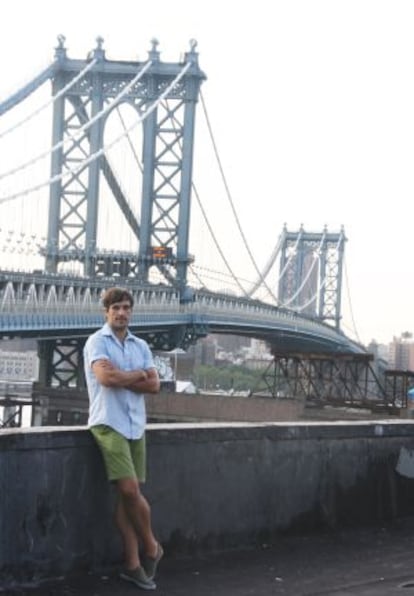 El artista visual Juanli Carrión con el puente de Manhattan al fondo.