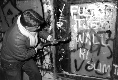 Un berlinés, con un pico de obra, golpea le muro levantado en agosto de 1961 para evitar la fuga de habitantes de la RDA a la Alamenia Occidental.