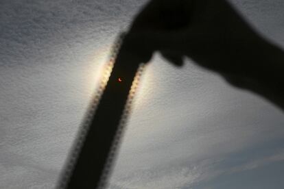 Una persona mira el eclipse solar a través de un negativo fotográfico en Szczecin (Polonia).