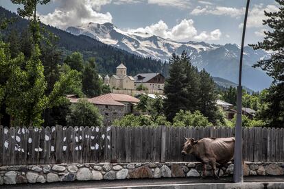 Vista de la cordillera desde la calle principal de Mestia (Georgia), con la iglesia de San Nicolás de frente y sobre el río Mulkhra. 