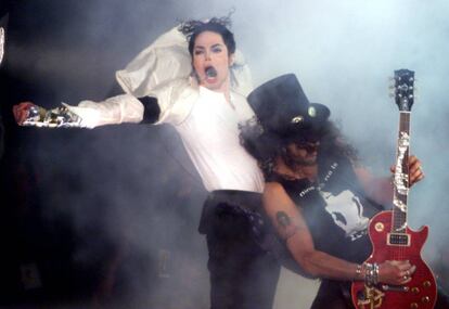 El cantante pasó varias veces por los quirófanos para someterse a operaciones estéticas, si bien el color blanquecino de su piel se debía al vitiligo (una enfermedad que causa despigmentación). En la imagen, el músico Michael Jackson junto al guitarrista de Slash durante su actuación en un concierto benéfico en junio de 1999.