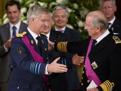 Alberto II y su hijo Felipe se abrazan durante el acto de abdicación.