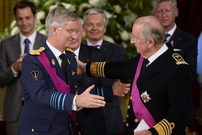 Alberto II y su hijo Felipe se abrazan durante el acto de abdicación.