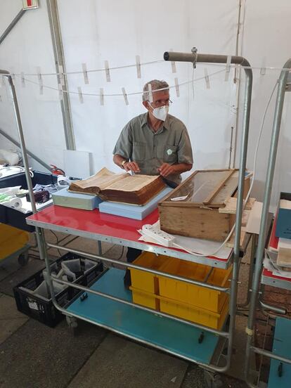 Un restaurador de la UCT con uno de los libros afectados por la humedad tras la extinción del fuego.