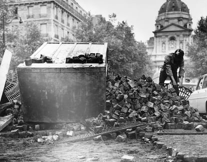 A young man builds a street barricade in Paris; May 1968.