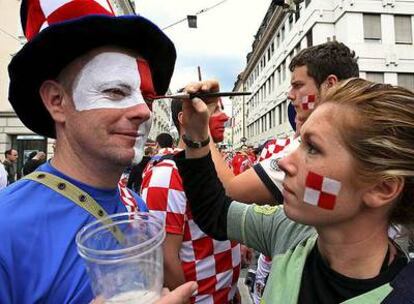 Aficionados croatas se pintan la cara antes de un partido.