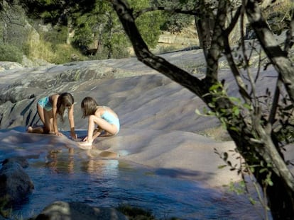 Dos niñas juegan y se bañan en Charca Verde de la Pedriza.