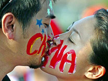 Mundial 2002, Brasil-China: dos aficionados chinos con las caras pintadas se besan antes del encuentro. PRIMER PLANO - ESCENA