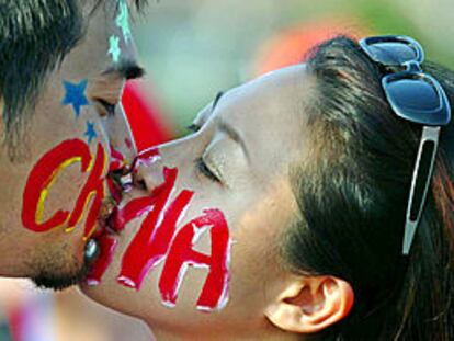 Mundial 2002, Brasil-China: dos aficionados chinos con las caras pintadas se besan antes del encuentro. PRIMER PLANO - ESCENA