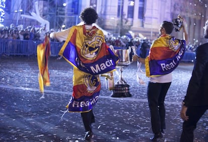 Jugadores del Real Madrid ofrecen el trofeo a los seguidores que abarrotaban la zona de Cibeles, en Madrid.