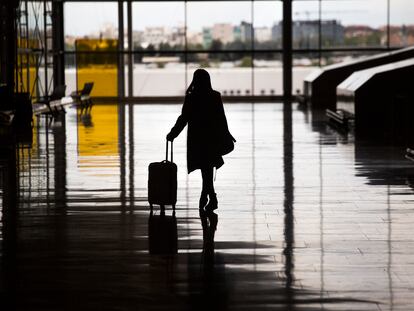 Una mujer con una maleta de mano en el aeropuerto de Madrid Barajas Adolfo Suárez.