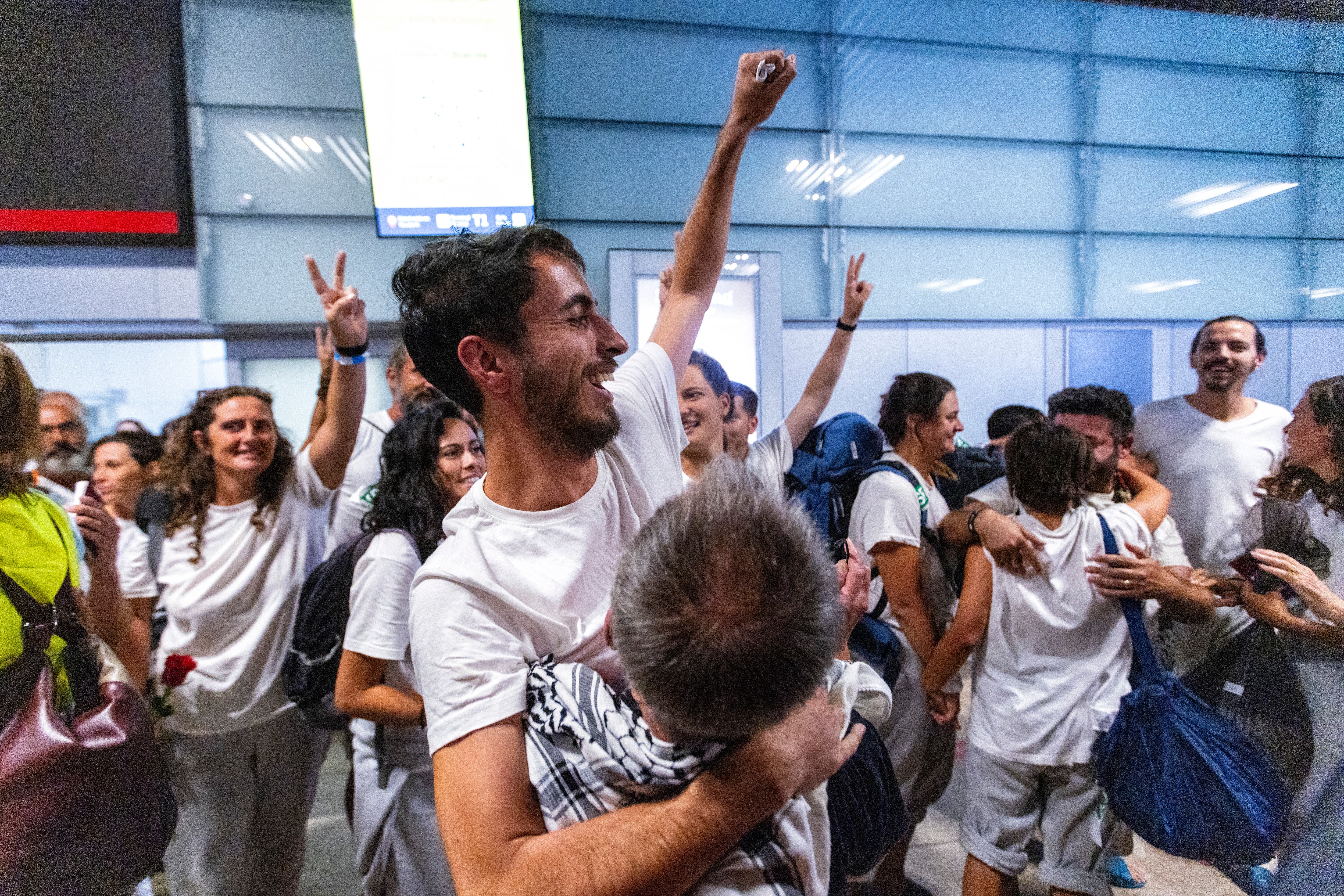 Los españoles deportados por Israel se abrazan a sus familiares y amigos este domingo en el aeropuerto de Madrid-Barajas.