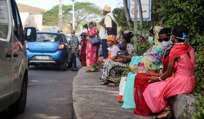 Varias pasajeras cubiertas con mascarilla esperan un taxi en Petite-Ile, en Mayotte.