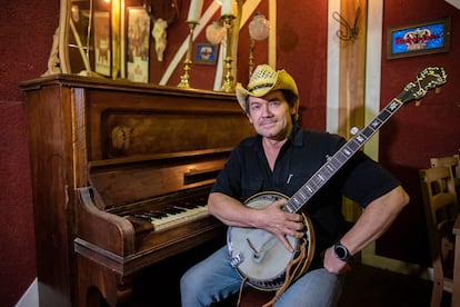 Greg Ryan, músico multinstrumentalista, fue uno de los primeros estadounidenses en traer la cultura 'country' a España. En la imagen, posa con uno de sus banjos en su local, El Barn d'en Greg, en la localidad de Rubí, en Barcelona