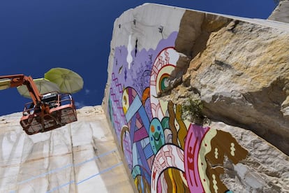 El artista mexicano del graffiti, Saïd Dokins, pinta sobre el muro de una pared de piedra caliza, en el muro de una pared de una cantera de piedra caliza, en Villars-Fontaine (Francia).