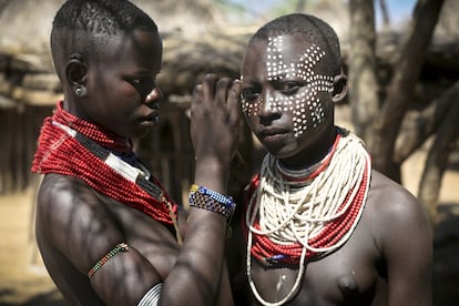 Un adolescente karo le pinta la cara a otro. La pintura corporal es una de las tradiciones ancestrales que mantiene esta tribu.