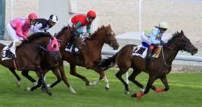 Varios jinetes durante la primera carrera de caballos disputada hoy en el Hipódromo de la Zarzuela, en Madrid.