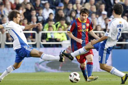 Messi intenta pasar el balón entre Ponzio y Ander Herrera, ayer en La Romareda.