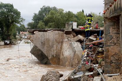 Bomberos inspeccionan un puente derrumbado por las inundaciones en Villegailhenc (Francia). Medio centenar de pueblos se encuentran incomunicados por la tromba de agua de más de 180 litros por metro cuadrado caída en la zona de Carcasona.