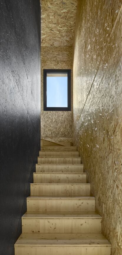 Es la tercera vez que el arquitecto Pep Zazurca y la interiorista Mar Ruiz trabajan juntos en el diseño de su vivienda, la primera en la que su hijo Santi colabora con ellos. En la imagen, detalle de la escalera en la que conviven los escalones de pino, las paredes de viruta OSB y el acabado negro mate, como en la cocina.