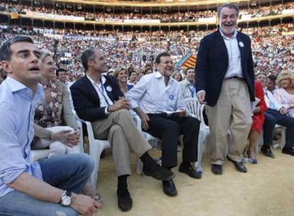 Mayor Oreja se levanta para subir al escenario en presencia de Rajoy y Camps en un mitin en Valencia el pasado martes.