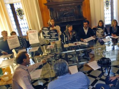 Farmac&eacute;uticos de Valencia muestran los carteles para denunciar los impagos de la Generalitat
