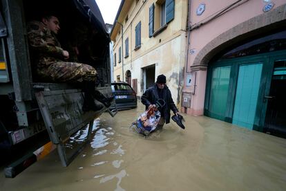 Un residente pasa junto a un camión del ejército en el pueblo inundado de Castel Bolognese, este miércoles.