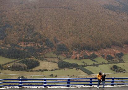 Dos personas se hacen una foto desde el mirador del valle de Belagoa, cuyos bosques presentan los colores típicos del otoño.