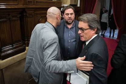 Romeva (izquierda), con Junqueras y Mas en el Parlament.