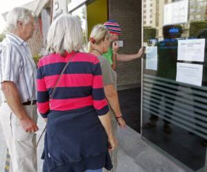 Turistas británicos leen los avisos de la compañia Britanny Ferries, que mantiene al ferry Cap Finisterre atracado desde el jueves pasado en el Puerto de Santander por la huelga convocada por algunos trabajadores de la naviera francesa, que tiene todos sus barcos parados en distintos puertos franceses, excepto el que está en Santander.