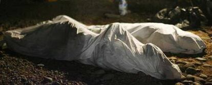 Los cuerpos de los dos inmigrantes fallecidos que llegaron el miércoles en un cayuco yacen en la playa de Archile, en Tenerife.
/ REUTERS
Uno de los inmigrantes rescatados por el <i>Segundo San Rafael</i> desembarca del <i>Esperanza del Mar</i> en Dakar.