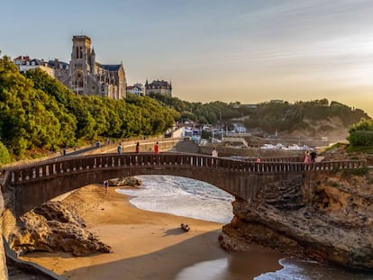 El puente de piedra de Rocher du Basta, en Biarritz, y, al fondo, la iglesia de Sainte Eugénie de la localidad francesa.