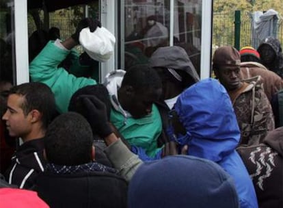 Un grupo de inmigrantes recoge bocadillos, ayer en la Cruz Roja de Baena.
