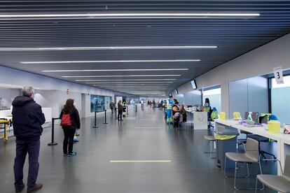 Varias personas hacen cola en el centro de vacunación instalado en el Wanda Metropolitano de Madrid.