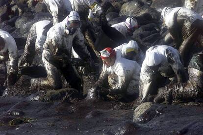 Voluntarios recogen chapapote en cabo Touriñán en diciembre de 2002.