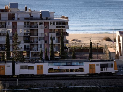 Un tren de Rodalies Renfe circula a la altura de la playa de Castelldefels, en Barcelona.