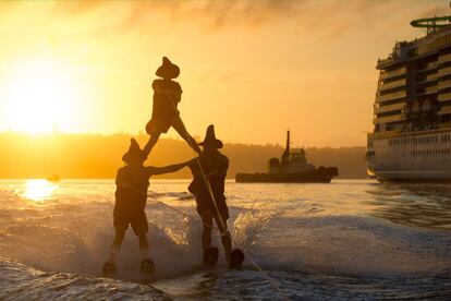 Varias personas practican esquí acuático disfrazadas de brujas, en el puerto de Sydney (Australia).