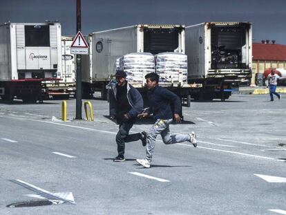 Jóvenes marroquíes corren ante la presencia de la Guardia Civil en el puerto de Ceuta. 